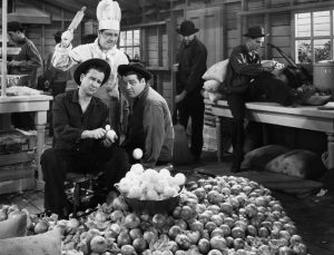 Publicity photo from Buck Privates, with Bud Abbott and Lou Costello peeling potatoes under Shemp Howard's supervision