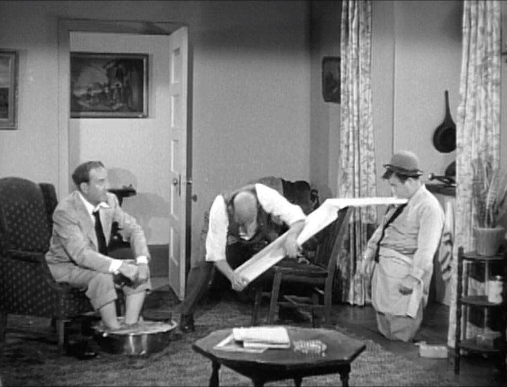 Sid Fields using the ironing board as a lever to get Lou out -- it breaks!