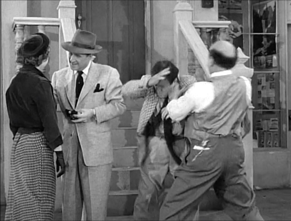 Bud Abbott chats with a pretty girl while Sid Fields beats up Lou Costello in "The Politician" - The Abbott and Costello Show season 1
