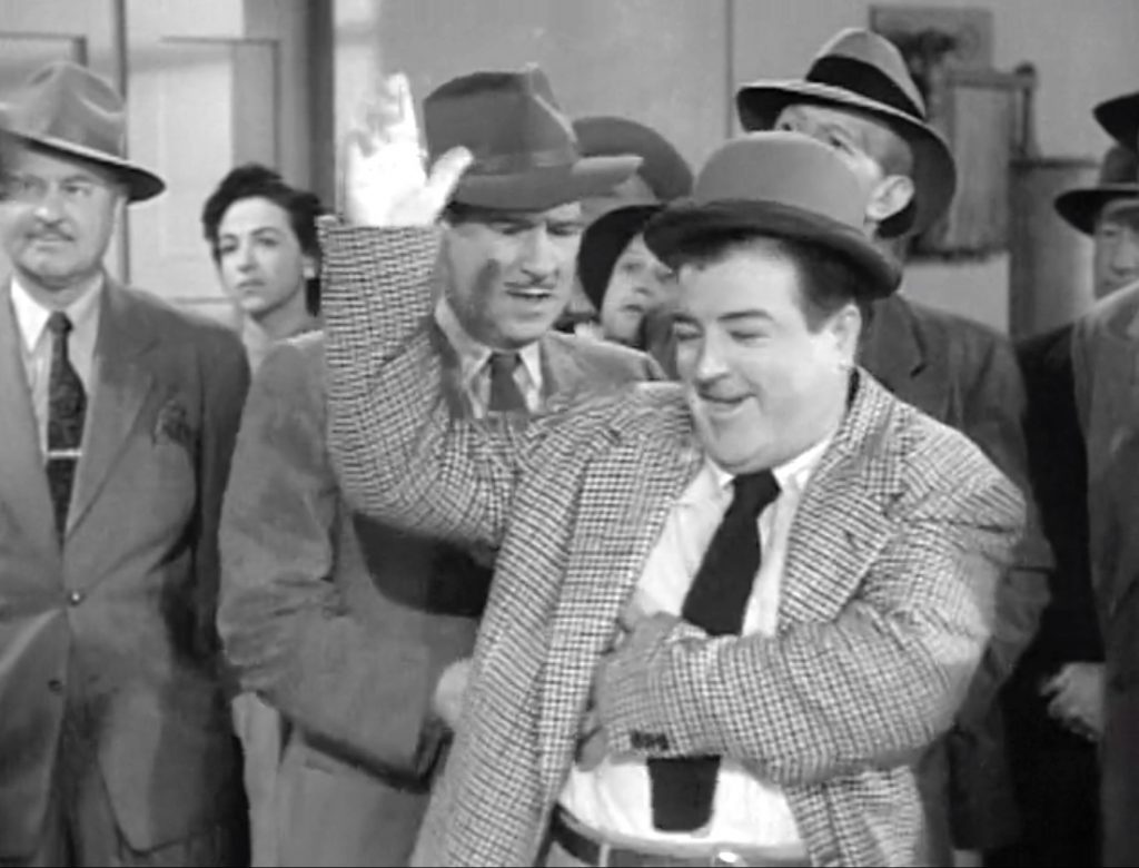 Lou Costello unintentionally bidding while Bud Abbott tries to stop him