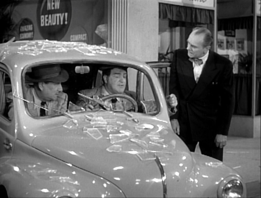 Bud and Lou drive through the dealership's display window!