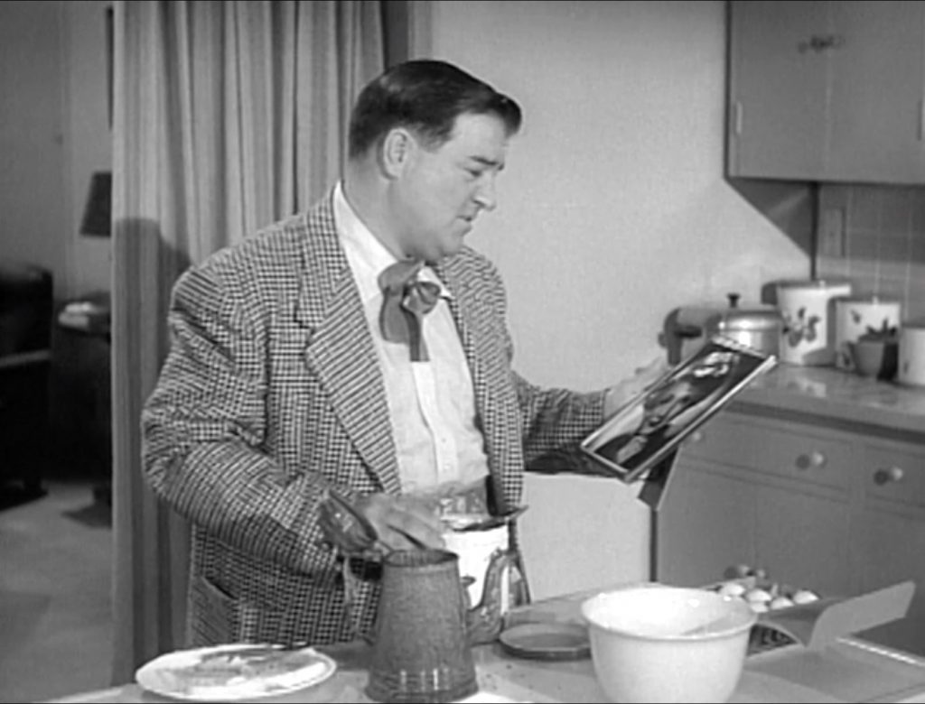 Lovesick Lou Costello making Bud's coffee, while mooning over Sally's photograph, in "Honeymoon House"